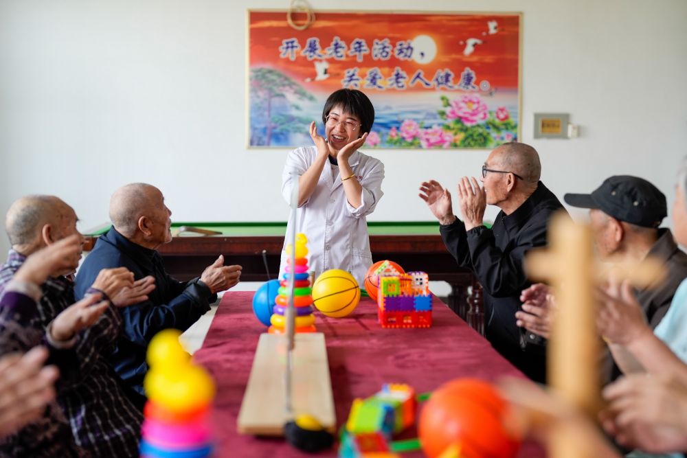 河北省滦南县一家养老机构的工作人员在陪老人做益智游戏（2023年5月19日摄）。新华社记者 牟宇 摄.jpeg