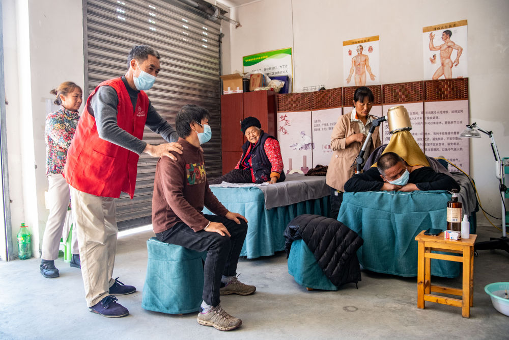 在重庆市綦江区安稳镇崇河村由当地民政部门建立的普惠养老场所“自然健康屋”，志愿者为老人提供免费理疗服务（2022年10月18日摄）。新华社记者 唐奕 摄.jpeg